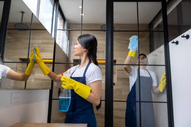 two cleaners are cleaning commercial building glasses